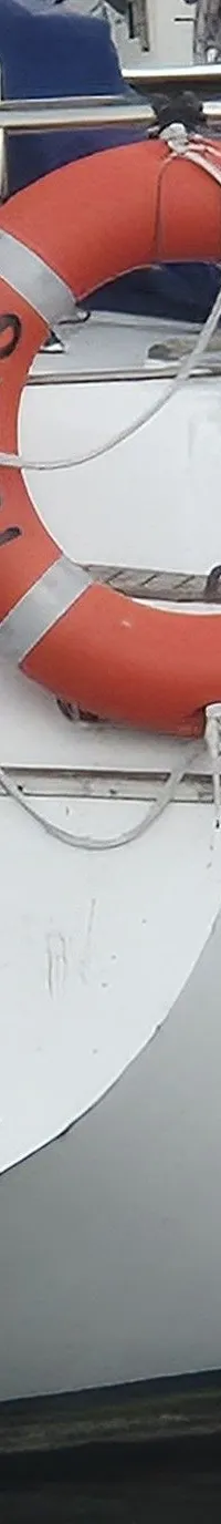 Een witte zeilboot met de naam "Turas" op de spiegel, een oranje reddingsboei en een zwemtrap. — Contest 36 Ketch