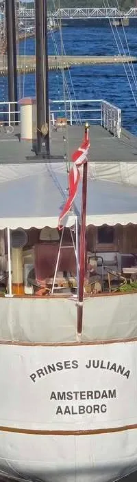 De witte boot toont haar spiegel met de naam "PRINSES JULIANA" en de thuishavens "AMSTERDAM AALBORG". — Horeca Schip 37.40