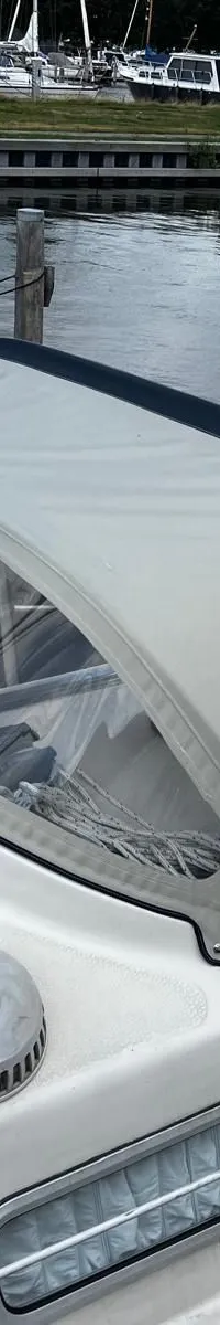 Een witte zeilboot met een lichtgrijze buiskap en de naam "ARABESQUE" op het dek ligt in een haven. — Arabesque 30