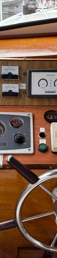 De foto toont een houten dashboard met een stuurwiel, diverse meters, schakelaars en een NASA-blokje.