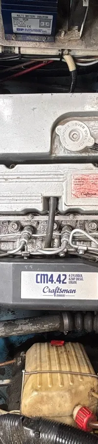 Een close-up van een scheepsmotor met de tekst "Craftsman CM4.42" op een zwart deksel.