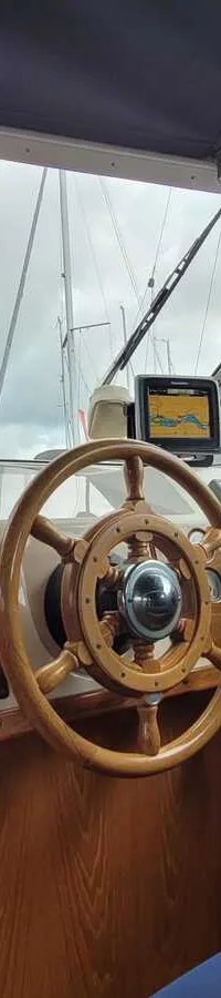 Interieur van een boot met houten stuurwiel, bedieningspaneel, kompas en navigatiescherm. — Agder 840 OK