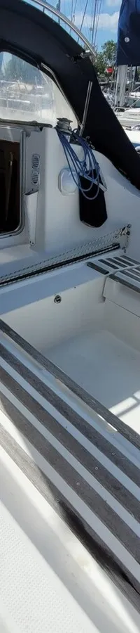 Een bovenaanzicht van de kuip van een zeilboot met een lier, touwen en een buiskap. — Beneteau First 310
