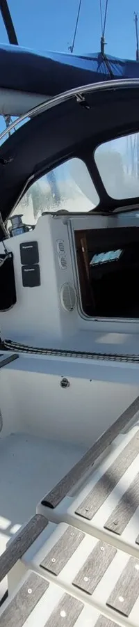 De foto toont de kuip van een zeilboot met een blauwe buiskap en een lier aan stuurboord. — Beneteau First 310