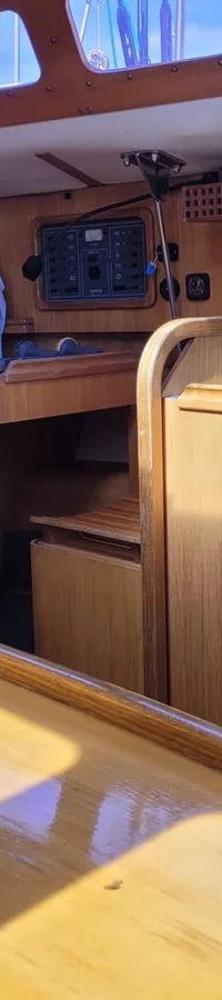 De foto toont het interieur van een boot met houten panelen, een blauwe bank en een houten tafel. — Feeling 346