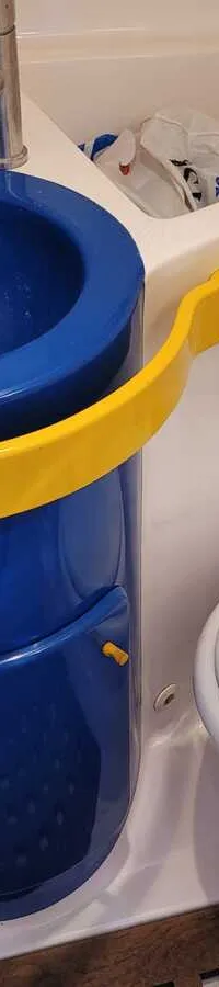 De foto toont een compacte toiletruimte met een blauwe wasbak, een kraan en een wit scheepstoilet.