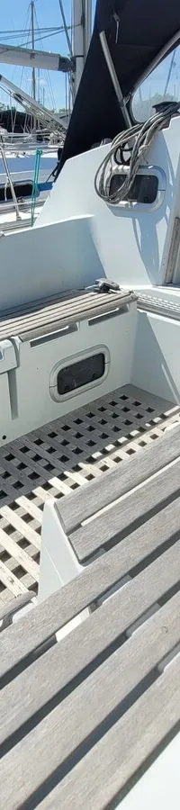 Een bovenaanzicht van de kuip van een zeilboot met teakhouten roosters en een open kajuitingang. — Feeling 346