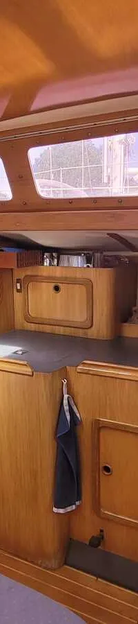 De foto toont het interieur van een boot met houten afwerking, een kombuis en een navigatiehoek. — Feeling 346