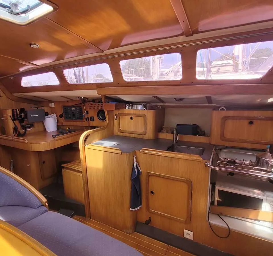 De foto toont het interieur van een boot met houten afwerking, een kombuis en een navigatiehoek. — Feeling 346