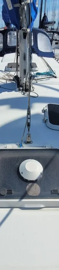 Het dek van een zeilboot met twee luiken en een mast, omringd door andere boten in een haven. — Feeling 346