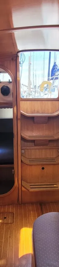 De foto toont het interieur van een boot met een kombuis, zithoek en twee slaapcabines. — Feeling 346