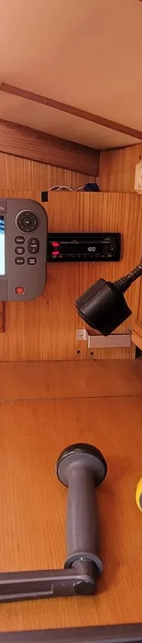 Een houten interieur van een boot met een Raymarine A Series display, een bedieningspaneel en twee lierenhendels.