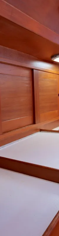 Een houten kajuit met een aanrecht, gootsteen, kraan, fornuis, en opbergruimte. — Luffe 46