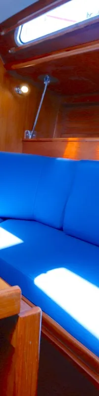 De foto toont een interieur van een boot met houten wanden, een blauwe bank en een houten tafel. — Luffe 46