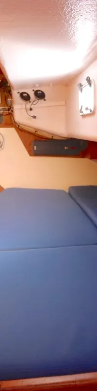 De foto toont een kajuit met een blauw matras, houten wanden en een wit plafond. — Luffe 46