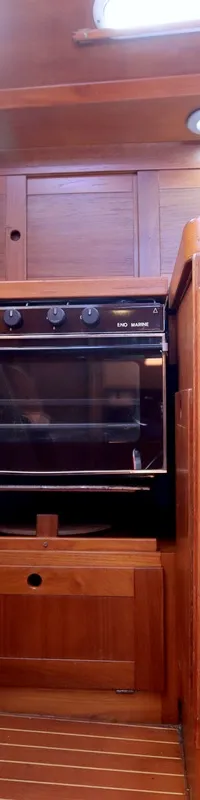 Een houten interieur met een fornuis en oven van ENO Marine, een trapje en een kraan.