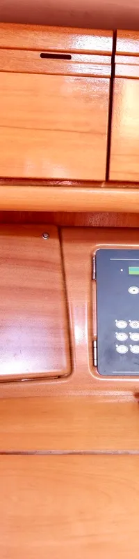 Een houten interieur met een marifoon, een schakelpaneel en een radio.