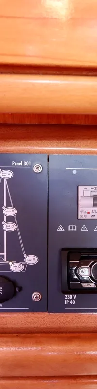 Een detailfoto van een donkergrijs bedieningspaneel met knoppen, schakelaars en een Pioneer radio, ingebouwd in een houten…