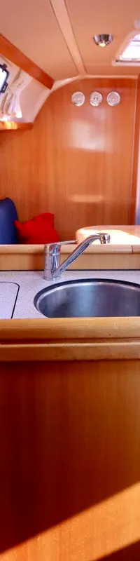 De foto toont het interieur van een boot met een kombuis, zithoeken en houten afwerking. — Bavaria 31