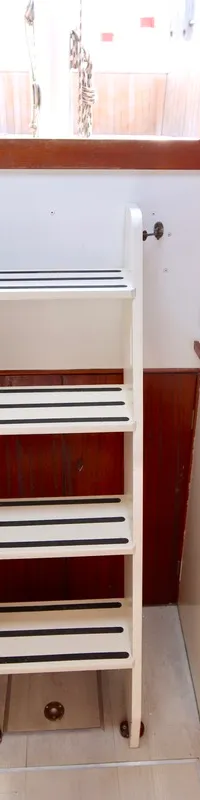 De foto toont het interieur van een boot met een kombuis, een trap en een slaapgedeelte. — Colin Archer Polar 34