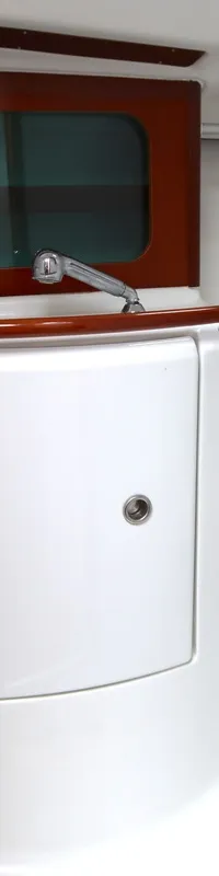 Een interieur van een boot met een wastafel, kraan, douchekop en een houten afwerking. — Beneteau Oceanis 311 Clipper