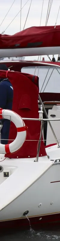 Een witte zeilboot met rode accenten en de naam "OCEANIS 311 Clipper" is te zien op het water. — Beneteau Oceanis 311 Clipper