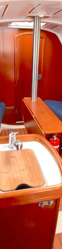 De foto toont het interieur van een boot met een kombuis, twee banken en een tafel. — Beneteau Oceanis 311 Clipper
