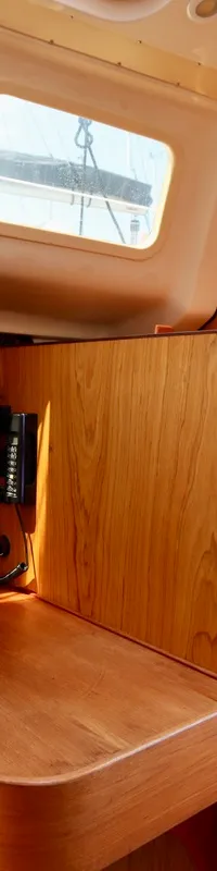 De foto toont het interieur van een boot met houten panelen, een bedieningspaneel, een brandblusser en ramen. — Hunter 340