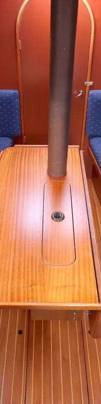 De foto toont het interieur van een boot met twee blauwe banken, een houten tafel en een houten vloer. — Dehler 34 Optima 106