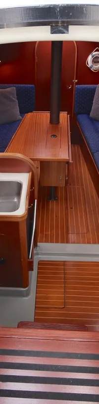 De foto toont het interieur van een boot met een kombuis, zithoek en houten vloer. — Dehler 34 Optima 106