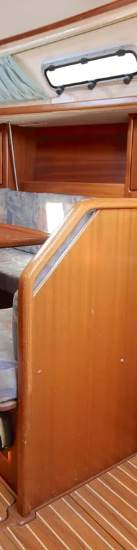 De houten kajuit toont een zithoek met tafel, een navigatiehoek en een brandblusser op de vloer. — Bavaria 35 Holiday