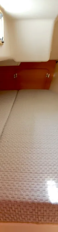 Een kajuit met een tweepersoonsbed, houten afwerking, een klein raam en een opbergplank is zichtbaar. — Etap 30i