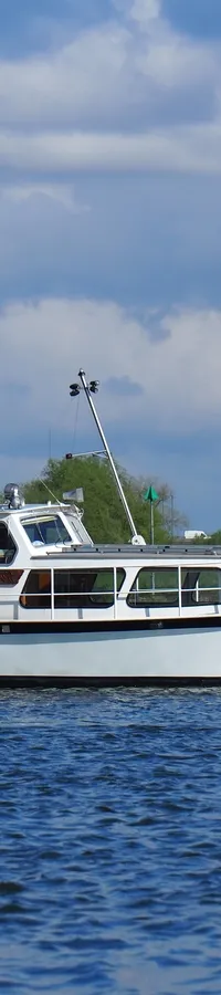 Een witte motorboot met blauwe kap vaart op het water onder een bewolkte hemel. — Cascaruda 920