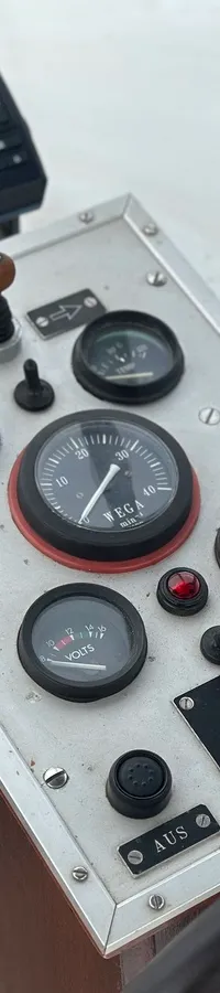 Een detailfoto van een stuurstand met een Garmin-apparaat, diverse meters en schakelaars, en een deel van een stuurwiel.