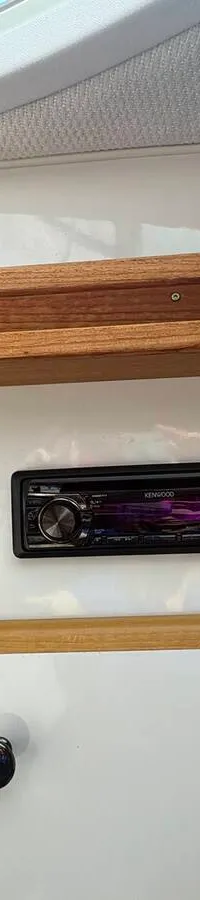 Een witte boot met zwarte accenten en de naam "Hydra" op de boeg staat op een gele trailer. — Maxum 3200 SCR