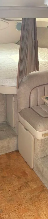 De foto toont een kajuit met twee banken met stoffen bekleding, een kurken vloer en een brandblusser. — Maxum 3200 SCR