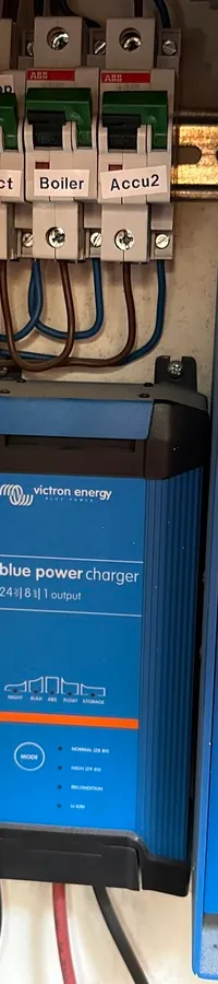 Een Victron Energy MultiPlus Compact en een Victron Blue Power Charger zijn gemonteerd naast een groepenkast met diverse…