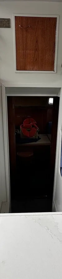 Een houten trap met witte stootborden en een blauwe bank met kussens zijn zichtbaar in de kajuit. — Neptunus 107