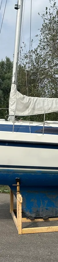 De foto toont een kajuit met een houten tafel, een grijze U-vormige bank en houten wanden met opbergvakken. — Compromis 777