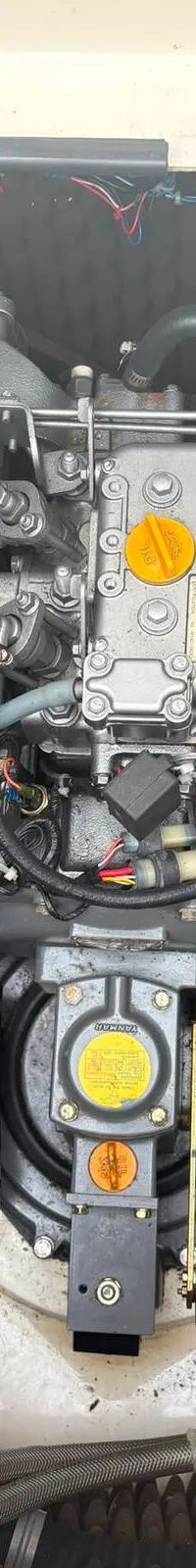 Een Yanmar scheepsmotor is zichtbaar in een motorruimte met geluidsisolatie.