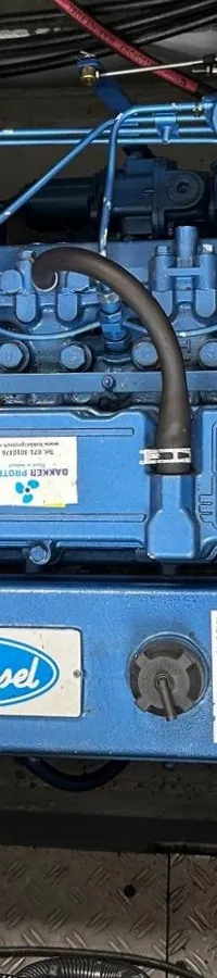 Een blauwe Solé Diesel motor met een zilverkleurige isolatiebuis en diverse slangen en kabels.