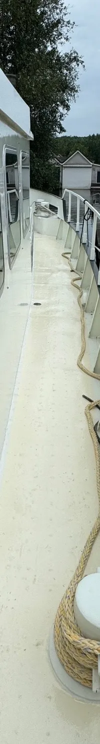 Een boot ligt aangemeerd aan een houten steiger, met een touw om een bolder gewikkeld.