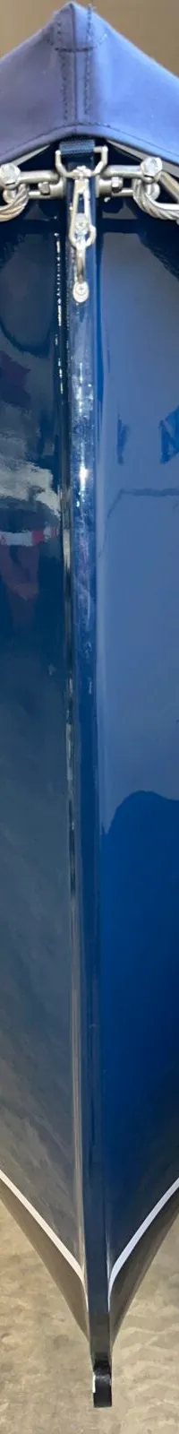 Een blauwe boot met de naam "Dutch Steel" in witte letters op de boeg, met een blauw afdekzeil en een grijze stootrand.