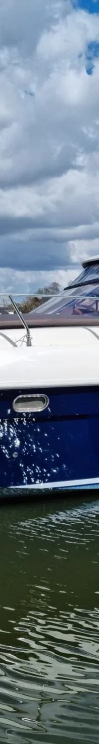 Een blauw-witte motorboot ligt aangemeerd in het water onder een bewolkte hemel. — Airon Airon Marine 425 HT