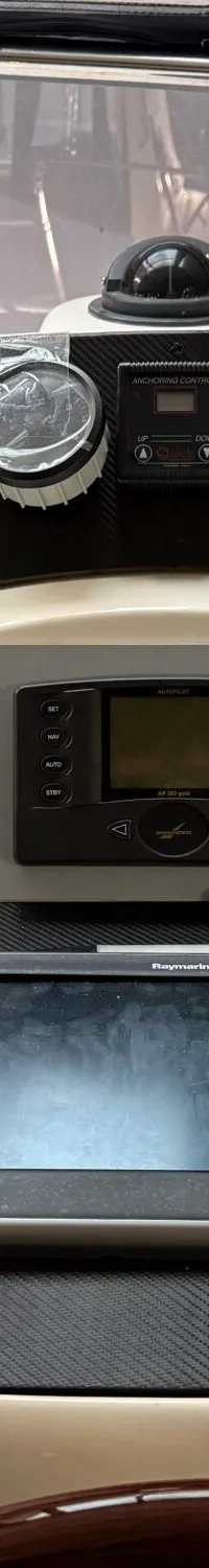 Een detailfoto van het dashboard van een boot met diverse meters, schakelaars, een kompas en twee navigatieschermen.