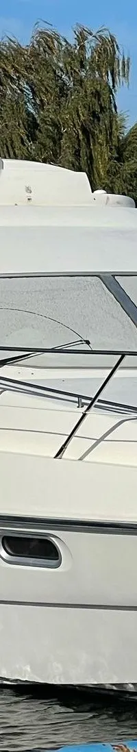 Een witte motorboot, met de naam "SEALINE" en "F34" zichtbaar, ligt aangemeerd in een haven. — Sealine Sealine F34 Flybridge