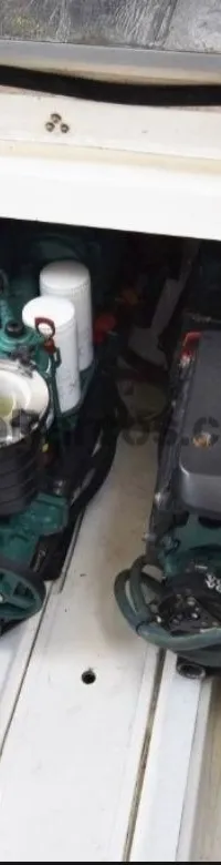 Twee Volvo Penta scheepsmotoren zijn zichtbaar in een motorruimte, met een deel van een buitenboordmotorsteun links.