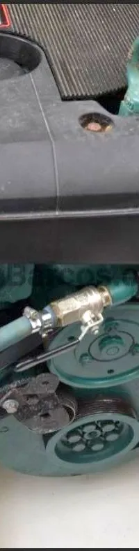Een Volvo Penta scheepsmotor met een zwarte afdekplaat en groene onderdelen is zichtbaar.