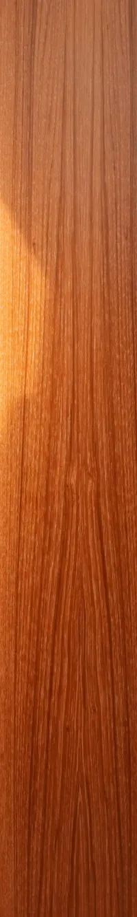 Een interieur van een boot met houten wanden, een witte bank en een tafel, en ramen met blauwe gordijnen.