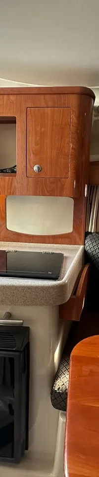 De foto toont een wit bootinterieur met een wasbak, twee bekerhouders en een opbergvak.